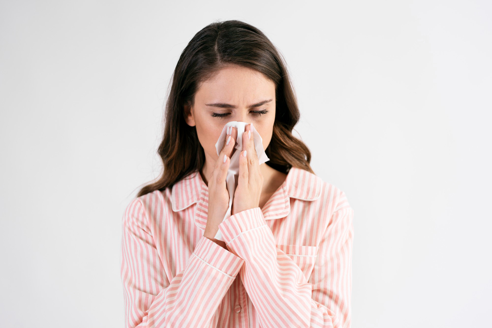 Sick Young Woman Blowing Nose