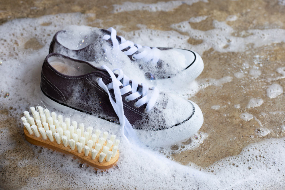 sneakers-with-foam-powder-detergent-water-dissolution-wooden-brush-cement-floor-washing-dirty-shoes