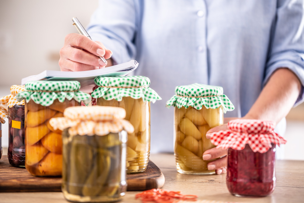 homemade-preserved-fruit-pickled-vegetable-with-woman-writing-down-recipe-background