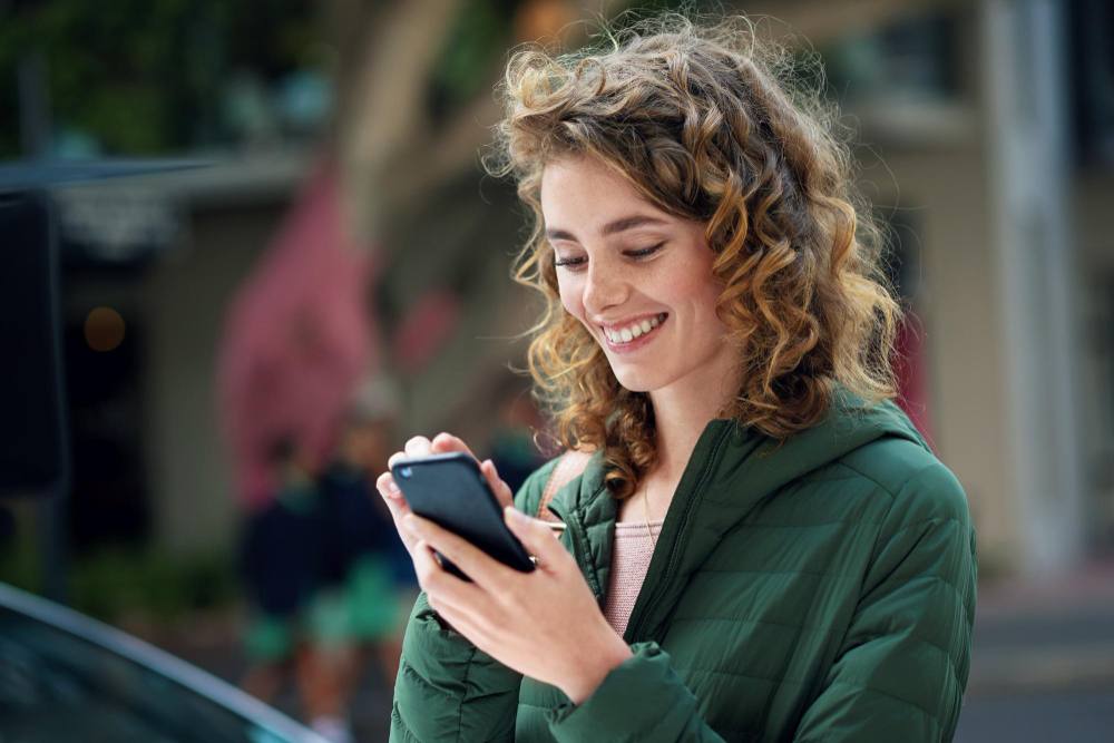 happy-woman-smile-typing-phone-during-travel-city-using-social-media-internet-5g-network-connection-outside-young-female-flirting-mobile-app-communication-urban-street