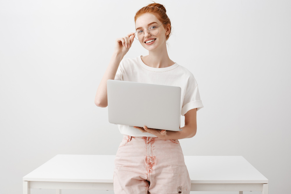 Smiling Redhead Girl Using Laptop Looking