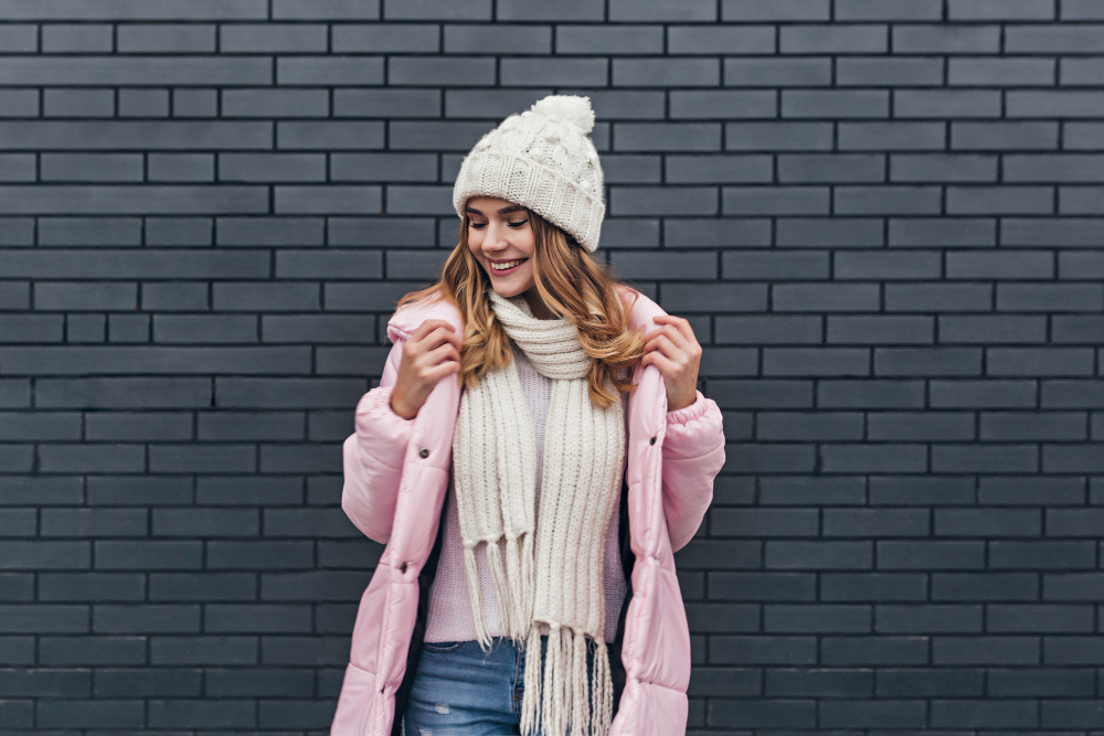 Amazing Girl With Beautiful Smile Enjoying Photoshoot Cold Morning Fashionable Blonde Female Model Coat Knitted Hat Posing Near Bricked Wall