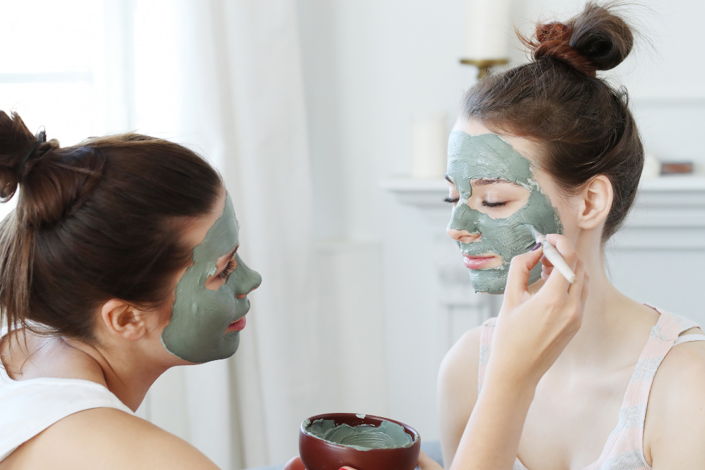 Woman Applying Facial Mask Her Friend Skin Care Concept