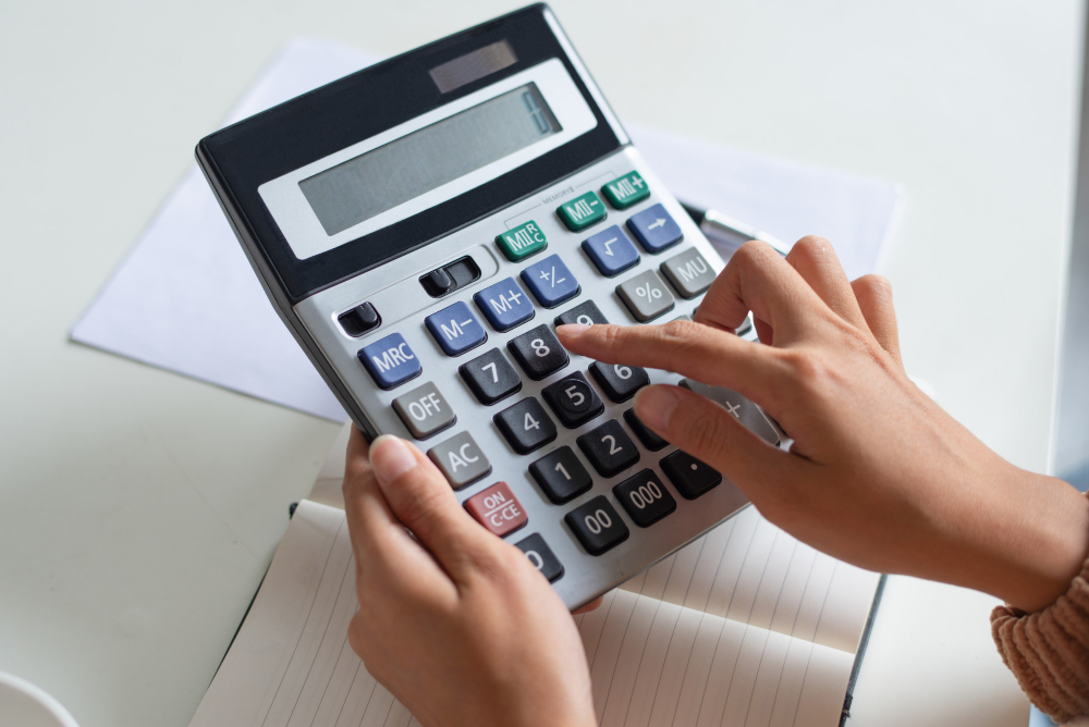 Close Up Accountant Using Calculator While Examining Report