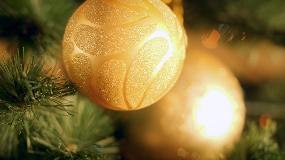 4k-footage-golden-bauble-hanging-christmas-tree-against-glowing-colorful-lights