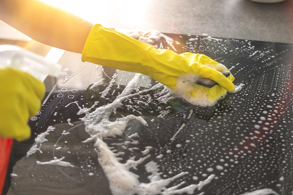 Hand Rubber Glove Cleaning Electric Stove With Spray Bottle Rag Sunny Day Kitchen Cleaning Concept Background Photo