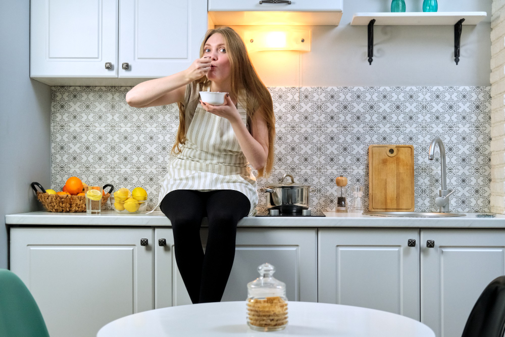 Young Woman Eats Kitchen Girl With Appetite Eating Homemade Freshly Prepared Food